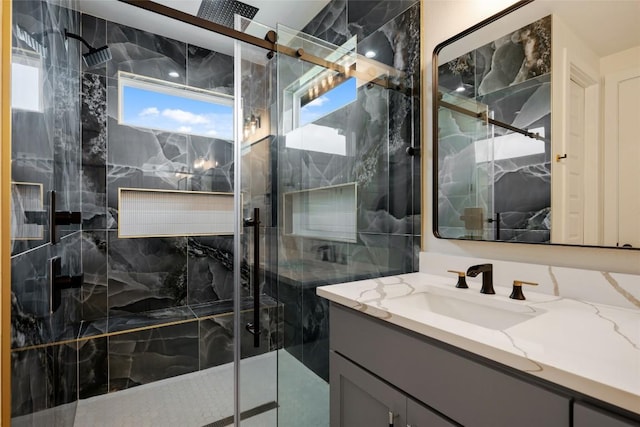 bathroom with vanity and a marble finish shower