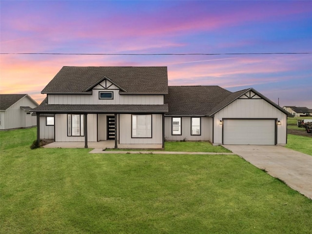 modern farmhouse featuring concrete driveway, board and batten siding, an attached garage, a front yard, and roof with shingles