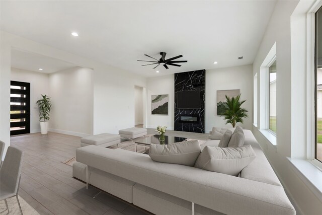 living room featuring ceiling fan and a premium fireplace