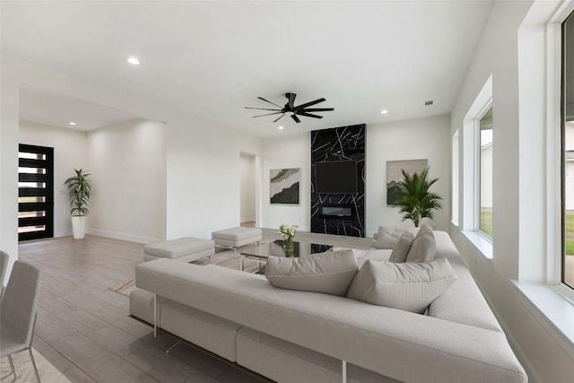 living area with baseboards, a ceiling fan, wood finished floors, and recessed lighting