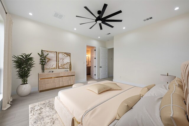 bedroom featuring ceiling fan, ensuite bath, and light hardwood / wood-style flooring