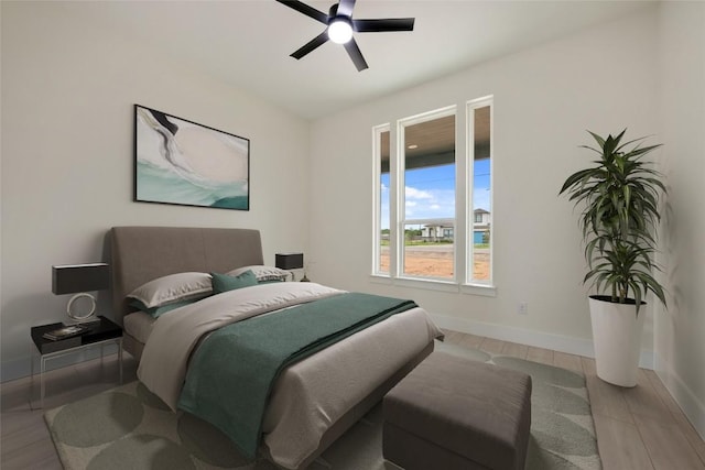 bedroom with wood finished floors, baseboards, and ceiling fan