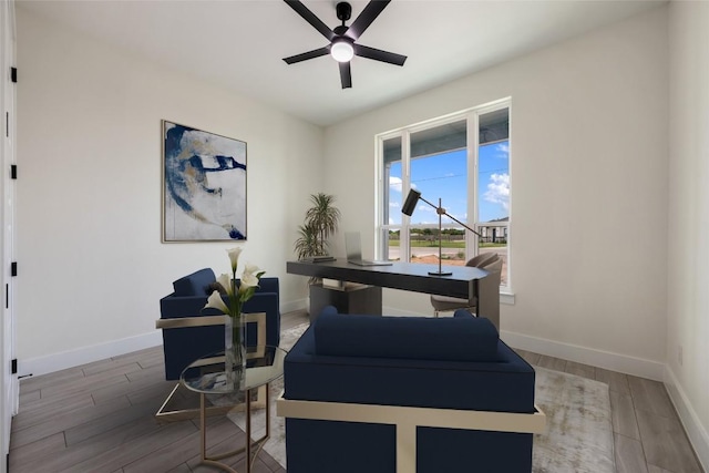 sitting room featuring baseboards, a ceiling fan, and wood finished floors