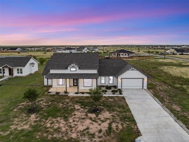 116 Bianca Cir, Del Valle, TX 78617 - modern farmhouse style home with covered porch, a garage, driveway, a front yard, and roof with shingles