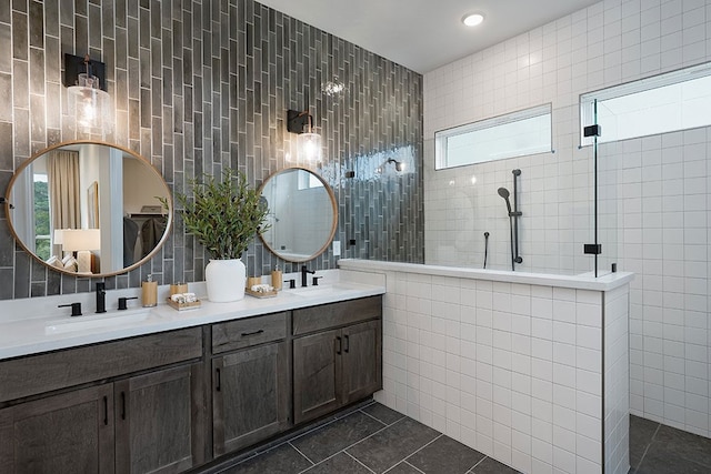 bathroom with vanity, walk in shower, tile walls, and tile patterned flooring