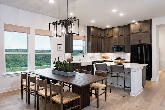 dining room featuring sink, a chandelier, and light hardwood / wood-style flooring