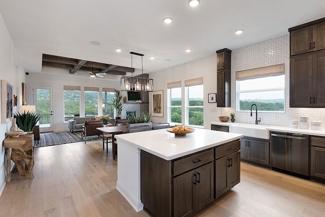 kitchen with stainless steel dishwasher, sink, plenty of natural light, and light wood-type flooring