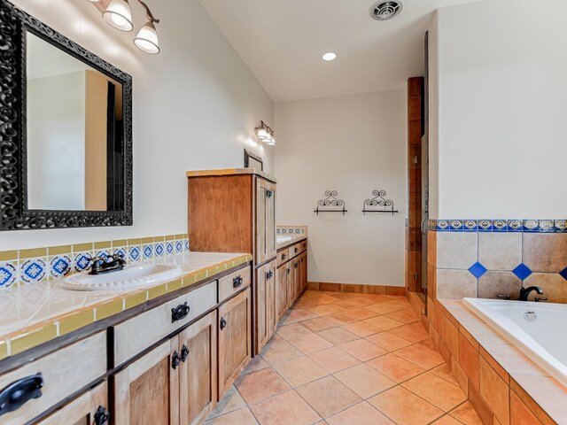 bathroom featuring vanity, tile patterned floors, and tiled bath