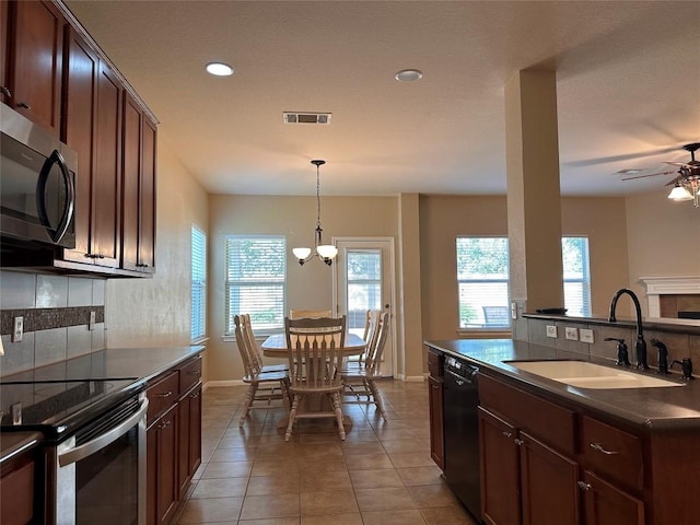 kitchen featuring decorative backsplash, sink, ceiling fan with notable chandelier, and appliances with stainless steel finishes