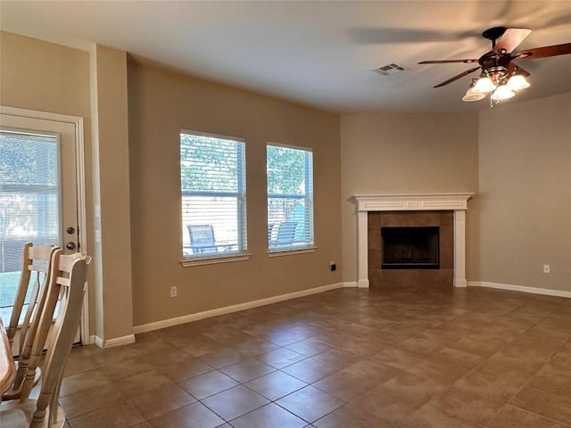 unfurnished living room featuring a tile fireplace, tile patterned floors, and ceiling fan