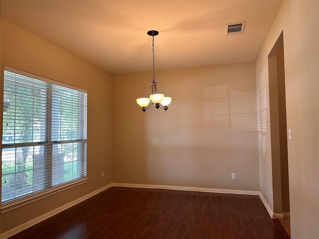 unfurnished room with dark wood-type flooring and a notable chandelier