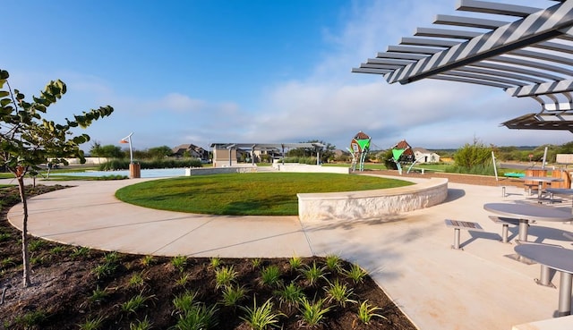 view of property's community with a water view, a lawn, and a playground