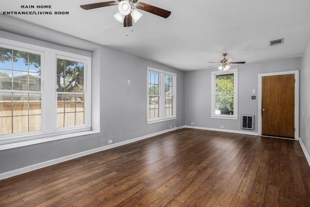 unfurnished living room with heating unit, ceiling fan, and dark hardwood / wood-style floors