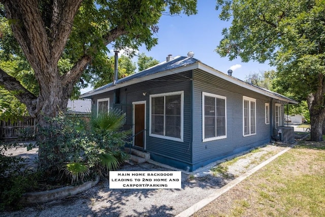 view of side of property with cooling unit and a lawn