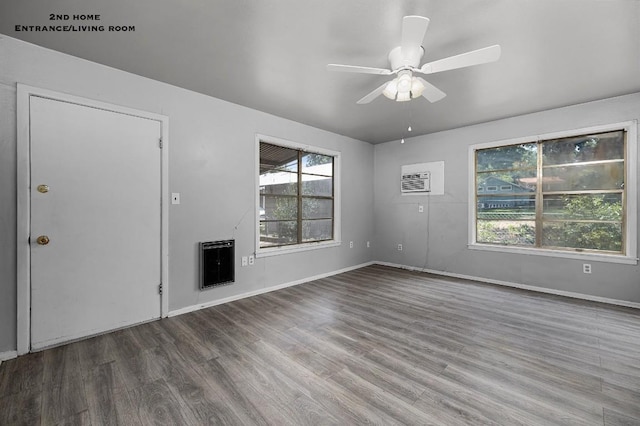 unfurnished living room featuring plenty of natural light, ceiling fan, hardwood / wood-style flooring, and heating unit