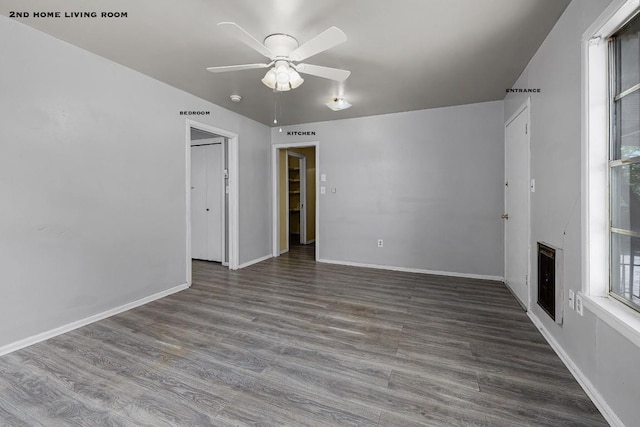 spare room featuring a fireplace, hardwood / wood-style floors, and ceiling fan