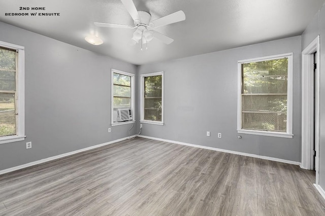 spare room with cooling unit, ceiling fan, and light hardwood / wood-style floors