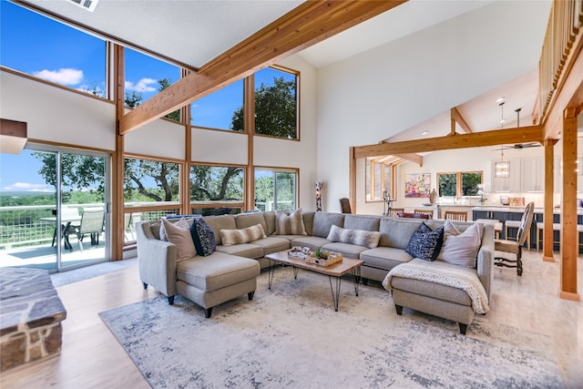 living room featuring a notable chandelier, beam ceiling, light wood-type flooring, and high vaulted ceiling