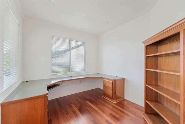 unfurnished office featuring a wealth of natural light, crown molding, wood-type flooring, and built in desk