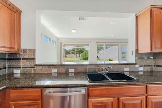 132 Belfalls Dr, Georgetown, TX 78633 - kitchen featuring stainless steel dishwasher, backsplash, dark stone counters, and brown cabinetry