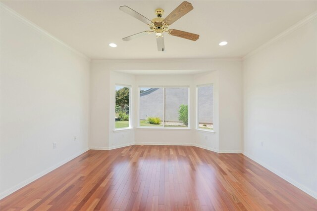 spare room with light wood-type flooring, ceiling fan, and ornamental molding