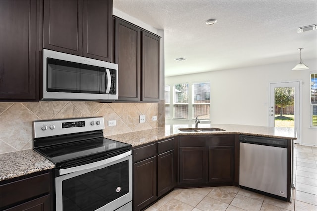 kitchen featuring dark brown cabinets, stainless steel appliances, kitchen peninsula, and sink