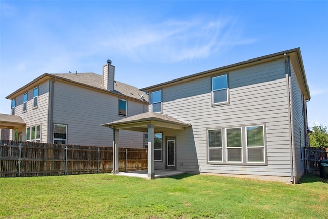 back of house featuring a lawn and a patio area