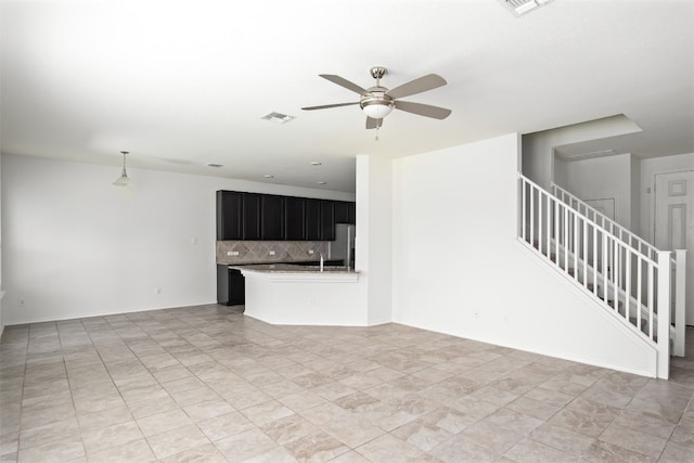 unfurnished living room featuring ceiling fan and sink