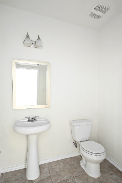 bathroom with toilet and tile patterned floors