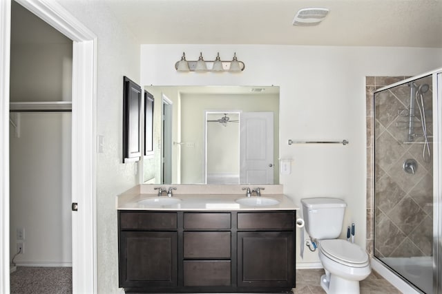 bathroom with vanity, toilet, tile patterned floors, and a shower with shower door