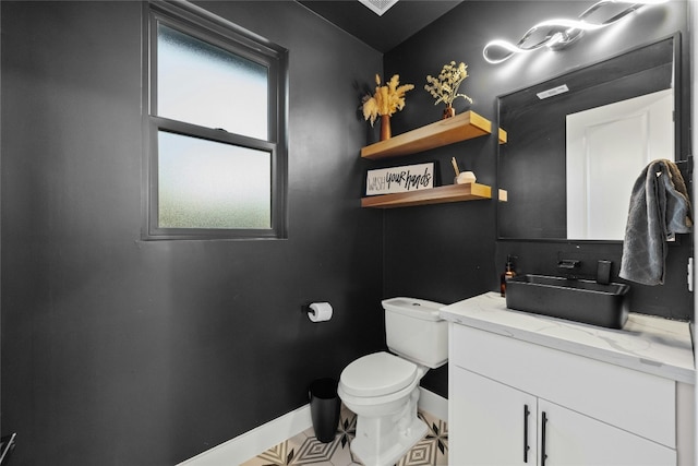 bathroom with toilet, a wealth of natural light, and vanity