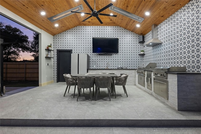 patio terrace at dusk with ceiling fan, grilling area, sink, and area for grilling