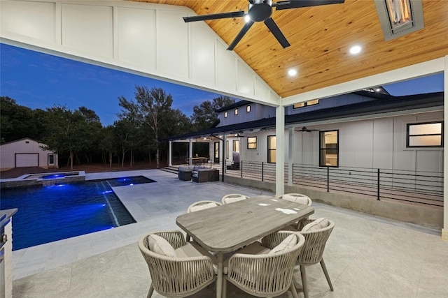 pool at twilight with pool water feature, ceiling fan, and a patio area