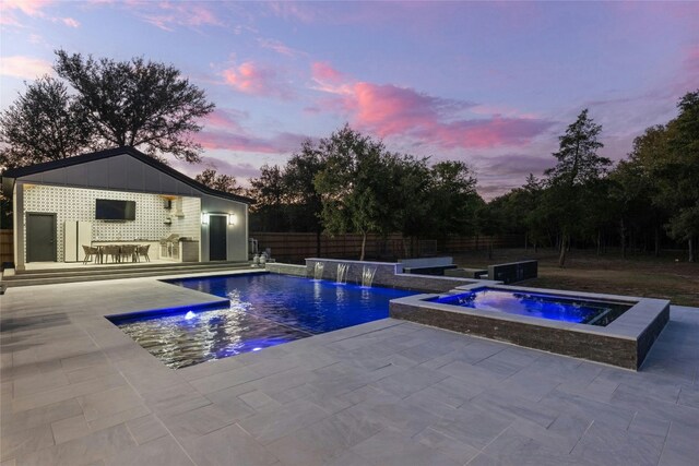 view of pool featuring an in ground hot tub, pool water feature, and a patio area