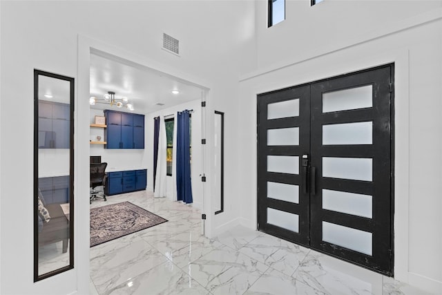 foyer featuring french doors and a high ceiling