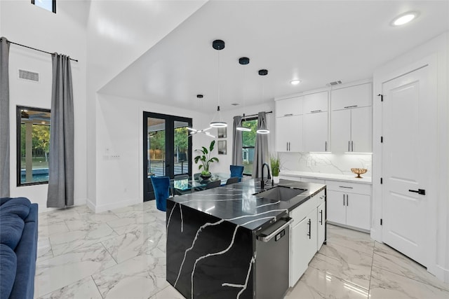 kitchen with hanging light fixtures, sink, white cabinetry, and a healthy amount of sunlight