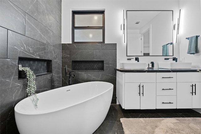 bathroom with tile patterned flooring, tile walls, vanity, and a washtub