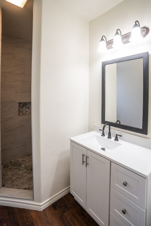 bathroom with a shower, hardwood / wood-style floors, and vanity