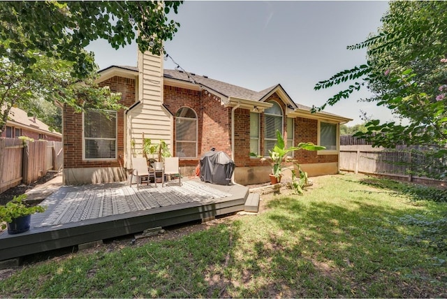 back of house featuring a deck and a lawn