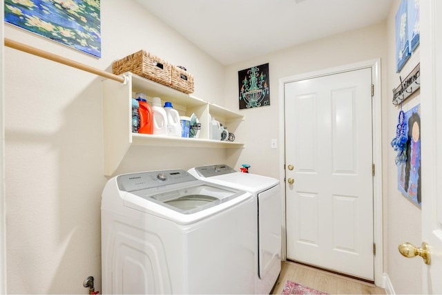 laundry area with light hardwood / wood-style flooring and independent washer and dryer