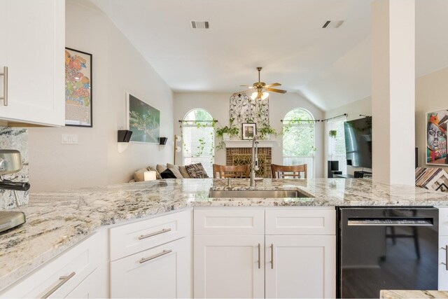 kitchen with dishwasher, sink, ceiling fan, vaulted ceiling, and white cabinets