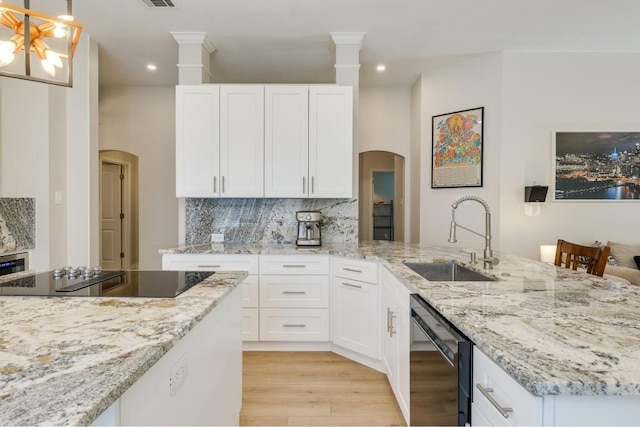 kitchen with white cabinets, light hardwood / wood-style floors, sink, black appliances, and pendant lighting