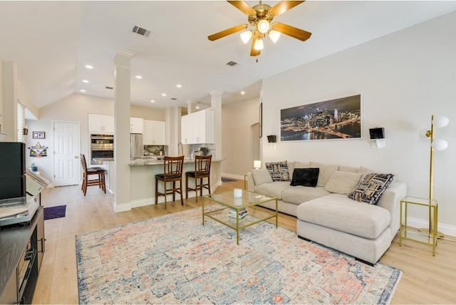 living room featuring vaulted ceiling, ornate columns, ceiling fan, and light hardwood / wood-style floors