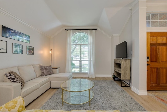 living room featuring lofted ceiling, light wood-type flooring, and ornamental molding