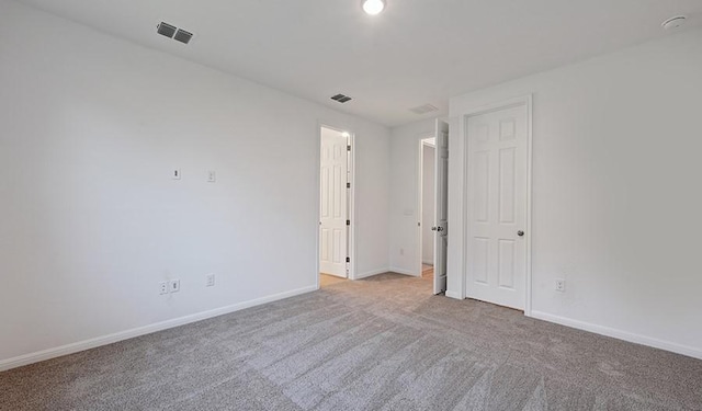 spare room featuring light colored carpet