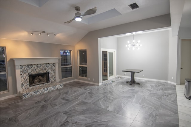 unfurnished living room featuring vaulted ceiling, a tiled fireplace, and ceiling fan with notable chandelier