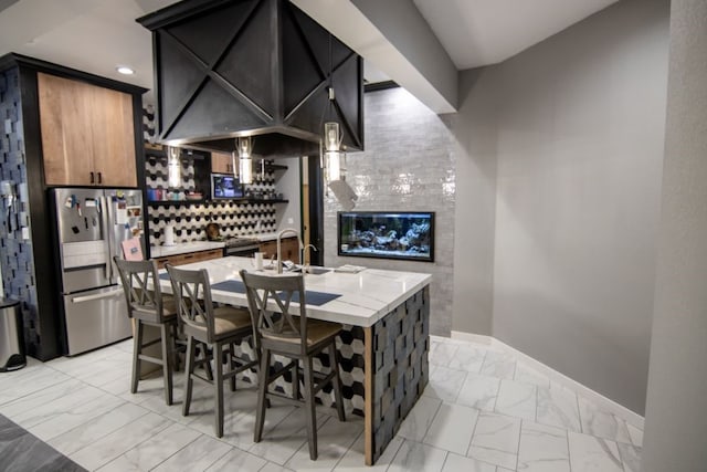 interior space with sink, stainless steel refrigerator, and light stone countertops