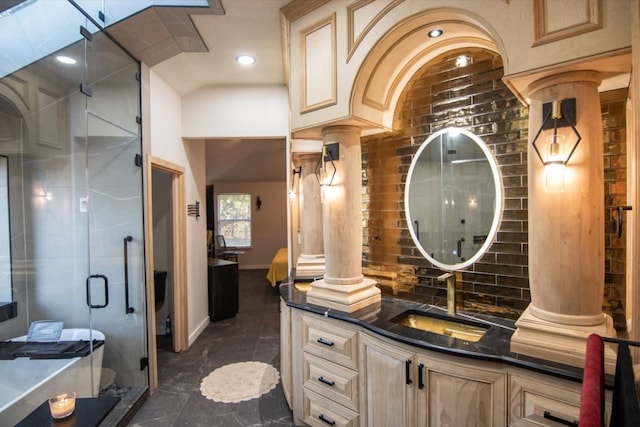 bathroom featuring lofted ceiling, decorative columns, a shower with door, and vanity