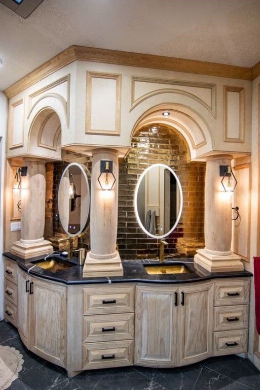 bathroom with brick wall, vanity, and ornate columns