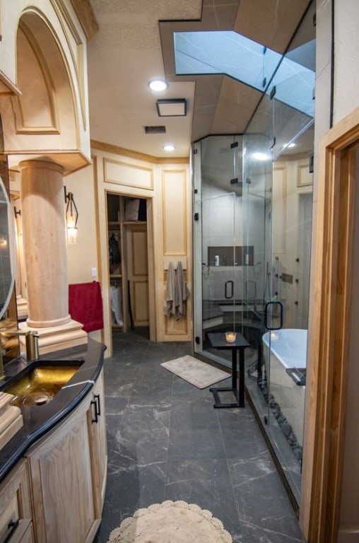 bathroom featuring vanity, plus walk in shower, and decorative columns